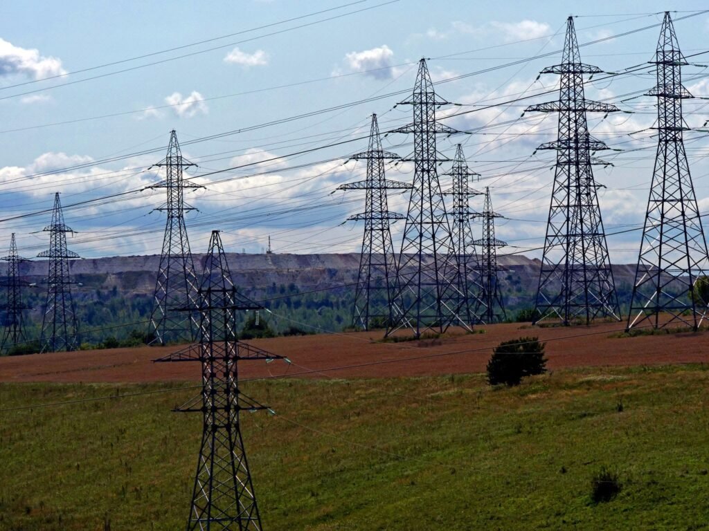 Steel high-voltage electricity pylons carrying transmission cables across countryside