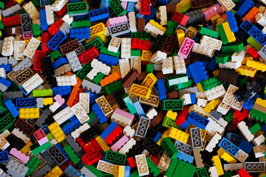 A large, chaotic pile of multi-colored Lego building bricks scattered together.